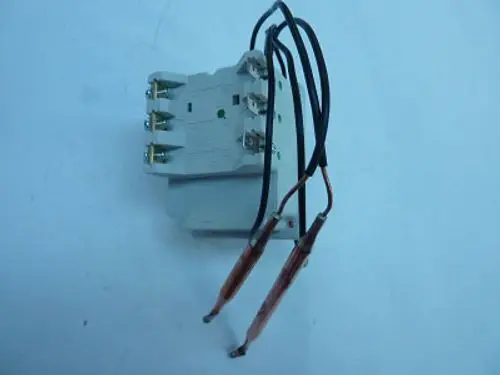 Thermostat von Remeha, kompakte Bauform mit mehreren Anschlussklemmen und zwei Drähten, auf hellblauem Hintergrund.